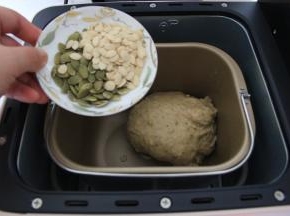 打开面包机盖，倒入瓜子仁。盖盖，继续直到程序结束，吐司烤好。全程不需要暂停。