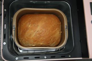 刚烤好，带隔热手套将面包桶取出。