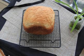 双手带隔热手套拿住面包桶，把吐司倒出来即可。如果搅拌叶片留在吐司上，可以等冷却后再取出。