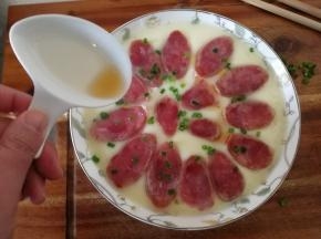 然后关火，取出蒸蛋。一股香肠的香味飘出来！淋上一点芝麻油。