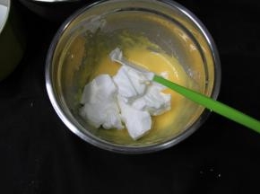 蛋白霜取1/3入蛋黄糊中，用刮刀（也可以用手动打蛋器）切拌、翻拌均匀，切记翻拌（类似炒菜）。