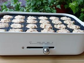 打开多功能锅，开大火，每个模具刷一点油，挖一勺馅放到多功能锅里，