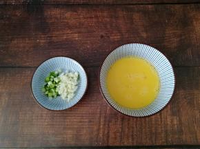 2个鸡蛋打入碗中，其实一个鸡蛋的蛋液就够了，我打了两个没有用完，大家可以打一个不要浪费了，小葱和大蒜切碎备用。