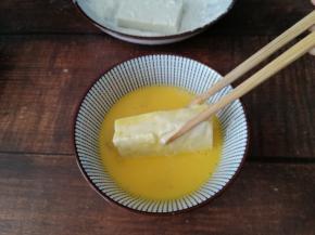 沾满淀粉的豆腐块，再蘸一层鸡蛋液。