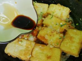 倒入生抽，大概2勺的量，再加半小碗清水，放入适量的盐，盖上锅盖，小火炖个三分钟，收一下汤汁，这个过程也是让豆腐入味的一个过程。