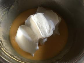 取三分之一的蛋白倒入蛋黄糊内，用刮刀轻轻平铺后切拌混合；