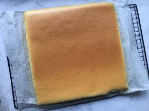 蛋糕出炉后从30CM高处将烤盘摔在桌面震出底部热气，然后提着油纸放在烤网上冷却；