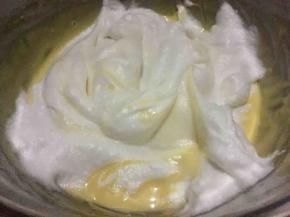 150度预热烤箱，取二分之一蛋白霜放入蛋黄糊盆中，先用刮刀轻轻将其刮散刮匀，再用翻拌手法使其快速混合；