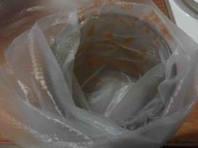 将裱花袋套在一个略有深度的宽口杯中，并将混合好的蛋黄糊倒入；