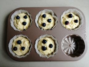 把蛋糕糊装入裱花袋，挤入一半的蛋糕糊，放入3颗蓝莓