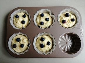 把蛋糕糊装入裱花袋，挤入一半的蛋糕糊，放入3颗蓝莓