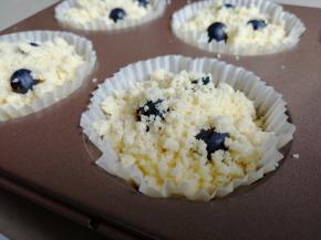 再挤入蛋糕糊，挤到八分满即可。在表面放上3颗蓝莓，再撒上酥粒