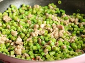 再加入豆角碎继续翻炒，至豆角变软。
