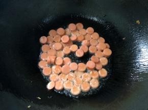 锅中留底油，倒入火腿肠翻炒
