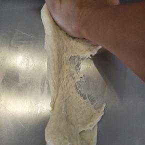 把水油面团，用搓衣服的方法把它搓透，能出一定的薄膜，拉扯面团不易断。