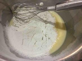 搅拌好的蛋黄液盆中筛入低筋面粉，用打蛋器搅拌至润滑的状态；