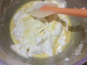 150度预热烤箱，取一半蛋白加入蛋黄糊内，先用刮刀轻轻将其刮散刮匀，再用翻拌手法使其快速混合；