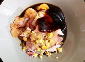 把切好的鸡肉放在碎中，倒入生抽和蚝油，姜末也一起丢进碗中