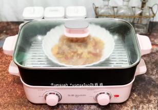 把腌制的鸡肉倒入盘中，送入锅中，蒸12分钟