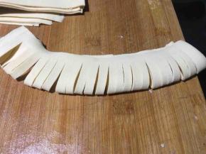 取出一小张对折，然后用刀均匀的切成3毫米宽的小细条，对折其边处不要切断，留出4毫米的宽度；