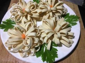 再将芹菜叶尖摘取洗净，摆放在花朵间空白处，增加色彩修饰；