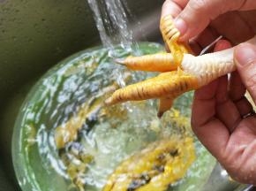 鸡爪用流动水冲洗，把外面那层皮剥掉。提前准备一盆凉白开，放到冰箱冷冻室做成冰水，等下要用来泡鸡爪的。然后剪去指甲，再把鸡爪分成两半。