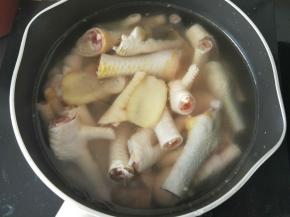 锅里放适量水，然后倒入鸡爪，再放入姜片，中火烧开后加入料酒，煮8分钟。