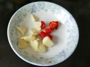 准备好一个碟子，蒜头去皮去成薄片放到碟子里，辣椒也切成小段，和蒜片放到一起。