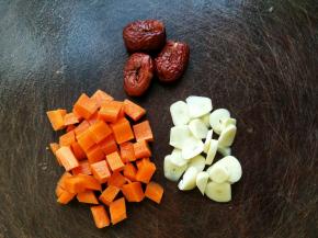 胡萝卜去皮切成小块，红枣拍一下后去核，蒜头剥皮后也切成片备用。