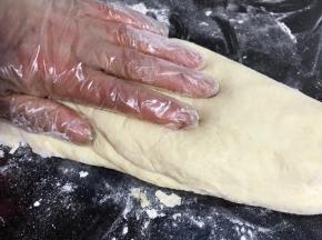 案板撒上少许干粉，取出面团按压排气