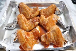 把腌制入味的鸡翅均匀的放在烤盘上，用牙签定型，鸡尖用锡纸包裹，避免烤糊。