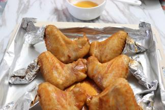 大约烘烤10分钟，取出烤盘，鸡翅刷上蜂蜜，再次放入烤箱烤