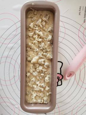 将面糊倒入学厨磅蛋糕模具中，震出气泡。表面撒酥粒。
