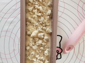 将面糊倒入学厨磅蛋糕模具中，震出气泡。表面撒酥粒。
