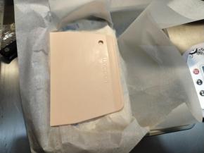 表面盖上一张油纸，用刮板辅助，整齐，然后冷却凝固。