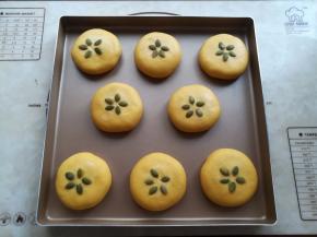 面团依次包好馅放入烤盘里，收口朝下，面团上取出抹一点水，放5颗南瓜籽