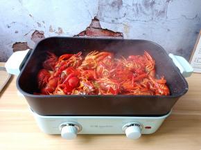 用铲子不停翻炒至龙虾全身通红盛盘备用。