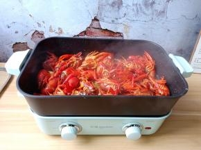 用铲子不停翻炒至龙虾全身通红盛盘备用。