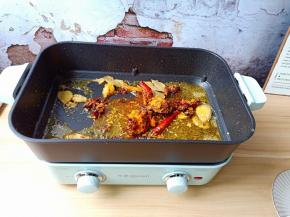 锅里留底油，加入火锅底料与香料翻炒出香味。