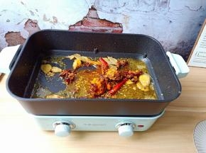 锅里留底油，加入火锅底料与香料翻炒出香味。