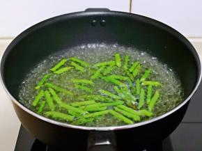 炒锅中加入纯净水，大火烧开，下入切好的芦笋，大火焯水1分钟立刻捞出过冷水。
