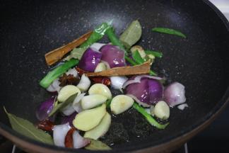 锅中倒入食用油，放入葱姜蒜、洋葱、干辣椒、桂皮、八角、香叶翻炒出香味。