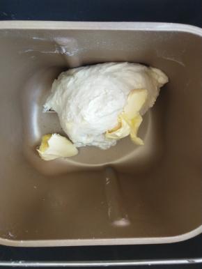 揉成团后加入软化的黄油继续揉。
