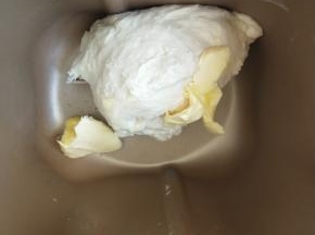 揉成团后加入软化的黄油继续揉。
