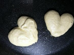 把蛋糕糊挤在平底锅中，挤出心形模样，锅边淋一点清水盖锅盖5分钟左右。