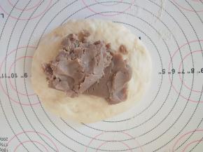 取一个小面团，擀开，包上适量栗子馅。

