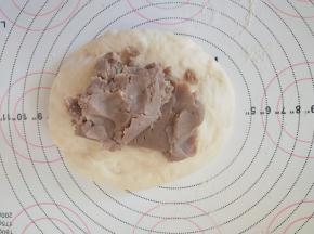 取一个小面团，擀开，包上适量栗子馅。
