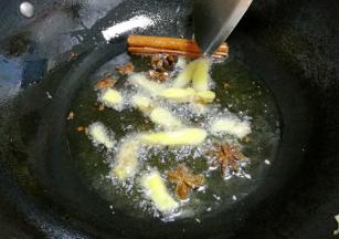 锅内加入油，小火煸香干辣椒、花椒、葱、姜、蒜，放入香叶、八角，炒香。