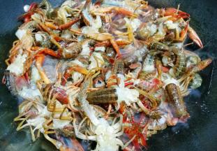 放入处理干净的小龙虾，翻炒均匀，放入料酒、生抽、蚝油，白糖，炒出香味。
