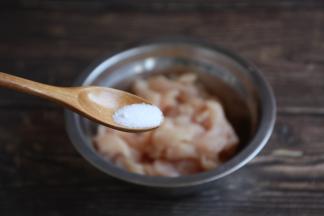 将去皮鸡腿肉放在一个较大的容器里，放入1g的盐。